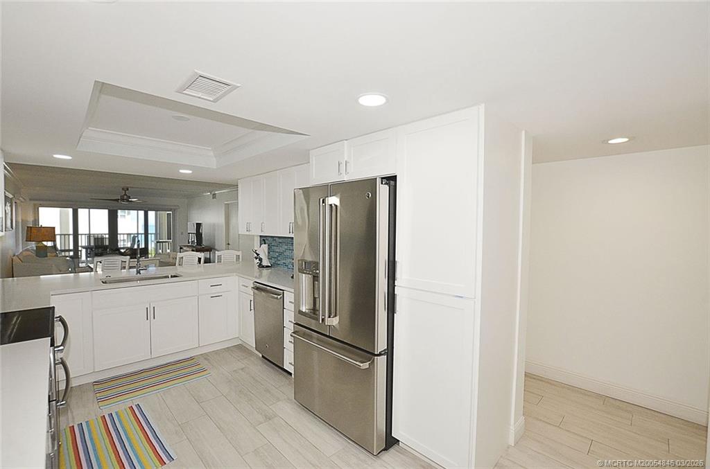 529 Northeast Plantation Road, Unit 310 Jensen Beach, FL 34957 - Photo 8 of 12 a kitchen with stainless steel appliances granite countertop a refrigerator and white cabinets