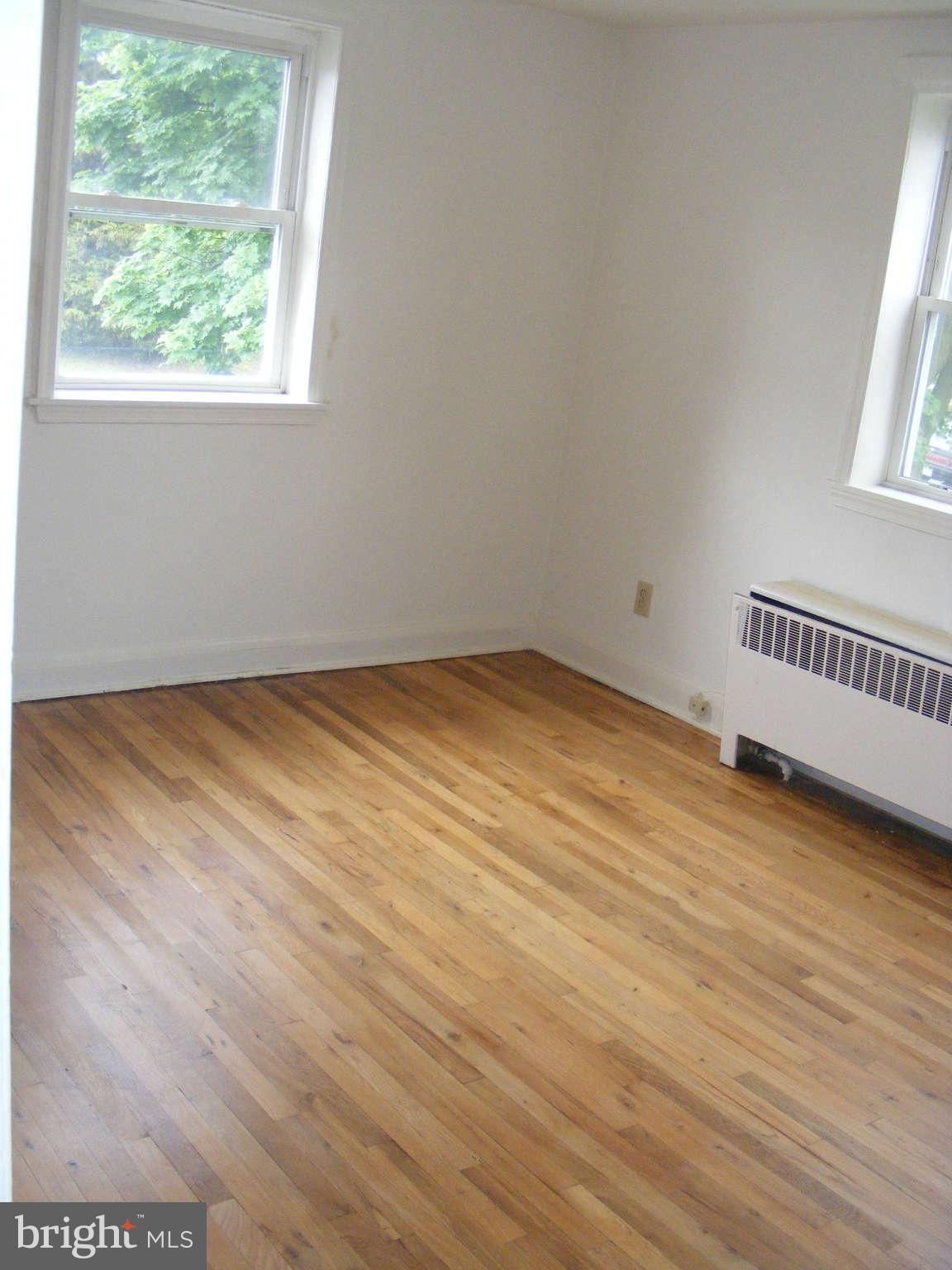 8503 Chestnut Oak Road Baltimore, MD 21234 - Photo 11 of 13 an empty room with wooden floor and windows