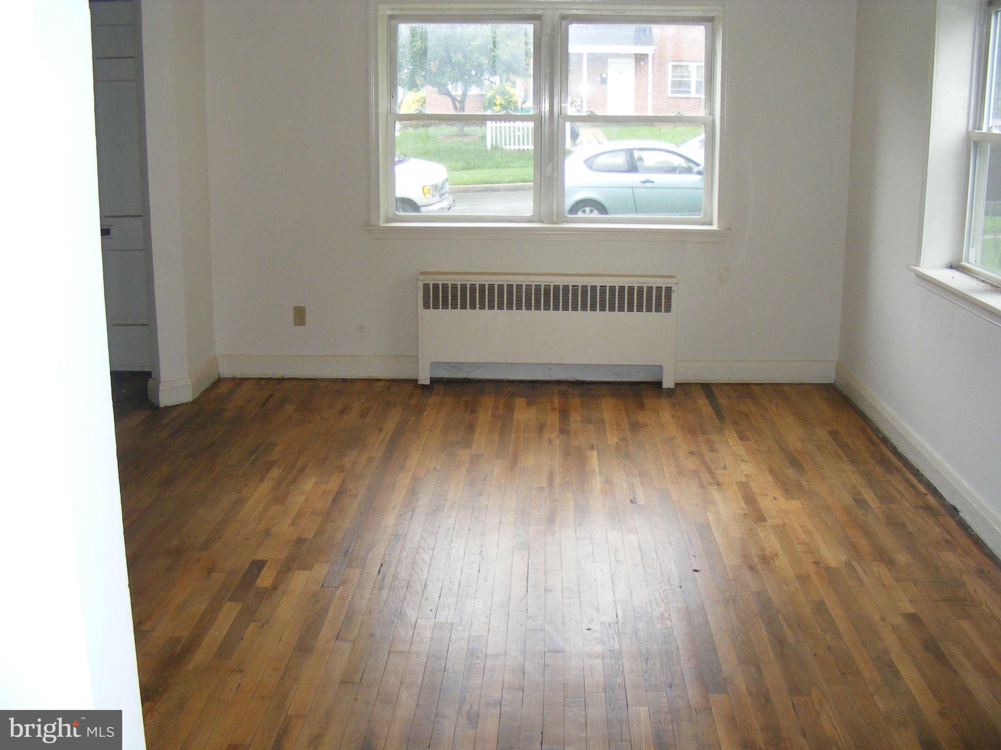 8503 Chestnut Oak Road Baltimore, MD 21234 - Photo 6 of 13 an empty room with wooden floor and windows