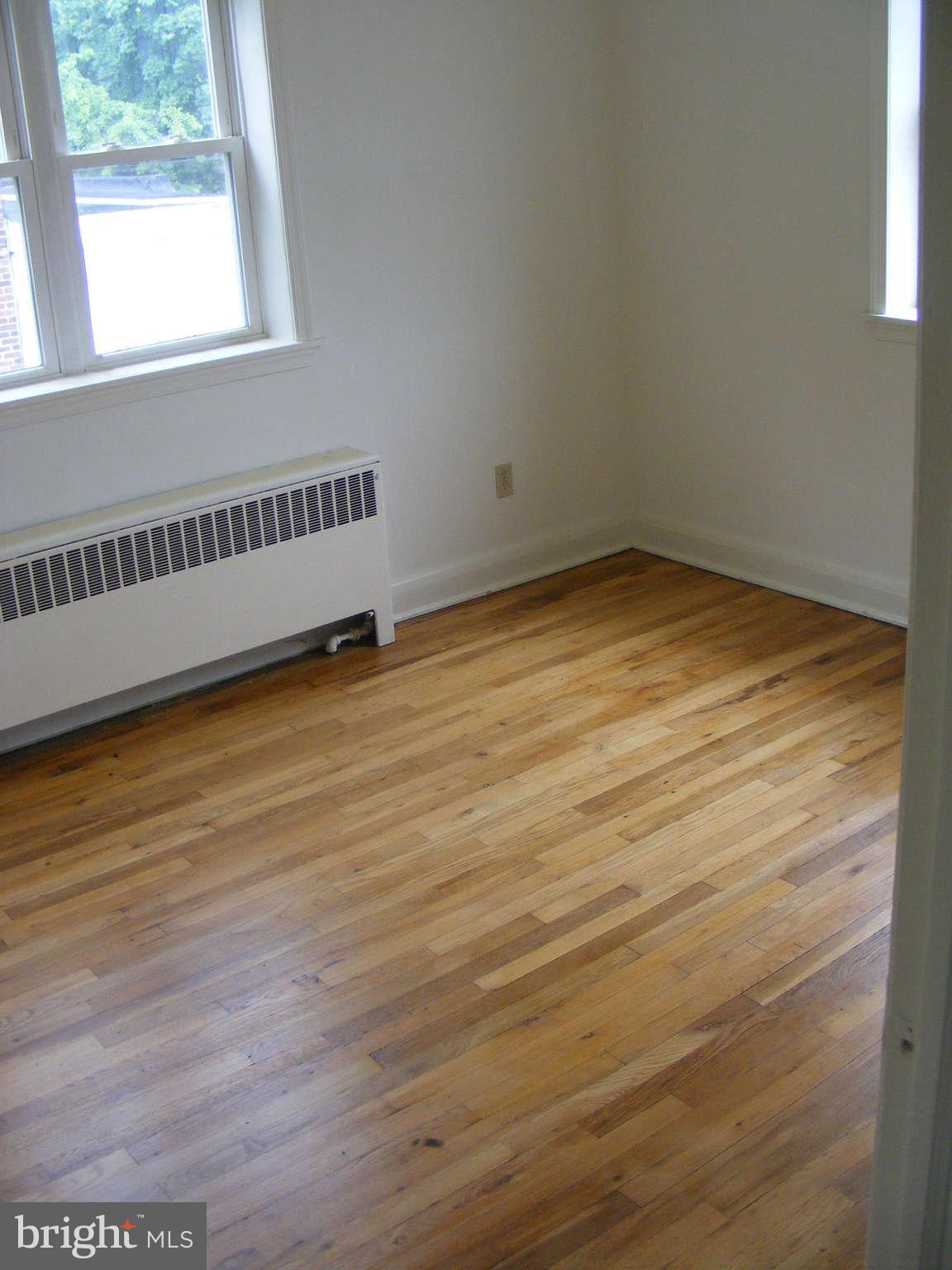 8503 Chestnut Oak Road Baltimore, MD 21234 - Photo 10 of 13 a view of an empty room with wooden floor and a window
