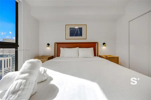 a bedroom with a bed and a painting on the wall