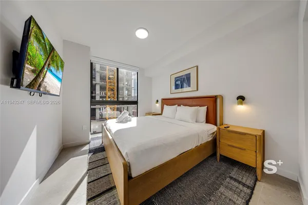 a bedroom with a bed and a flat screen tv