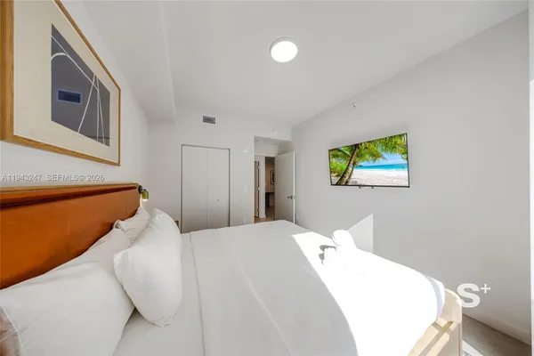a bedroom with a bed and a painting on the wall