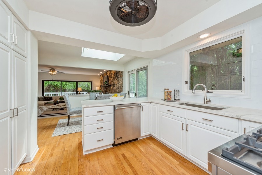 223 Brookbridge Road Trout Valley, IL 60013 - Photo 10 of 33 a kitchen with a sink dishwasher a stove and white cabinets with wooden floor