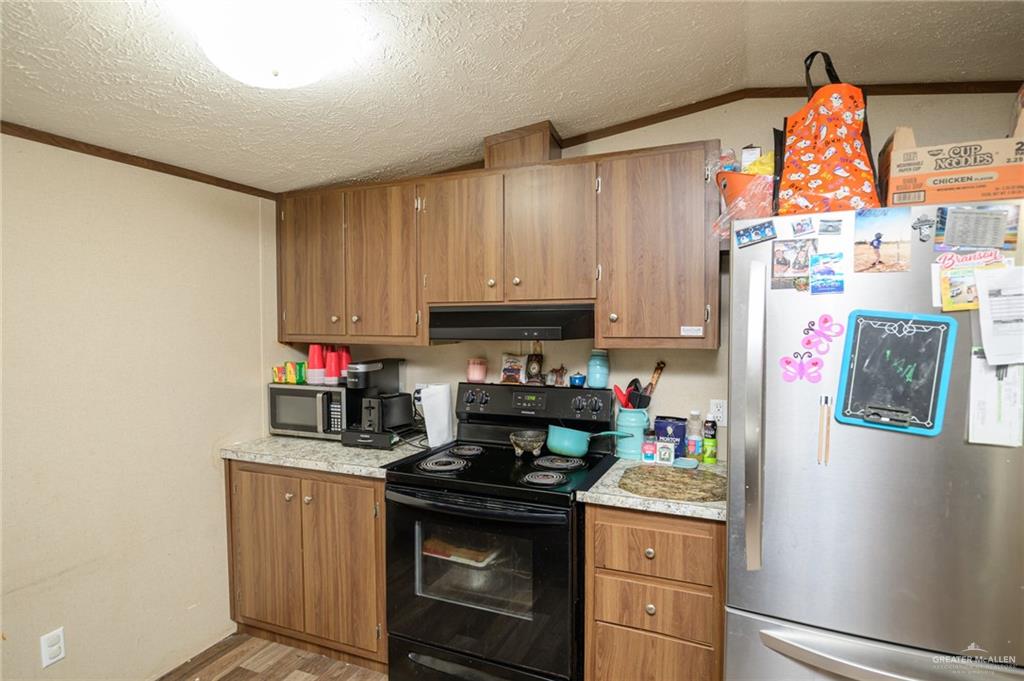 818 South 13th Street Alamo, TX 78516 - Photo 7 of 24 a kitchen with stainless steel appliances granite countertop a refrigerator stove and sink