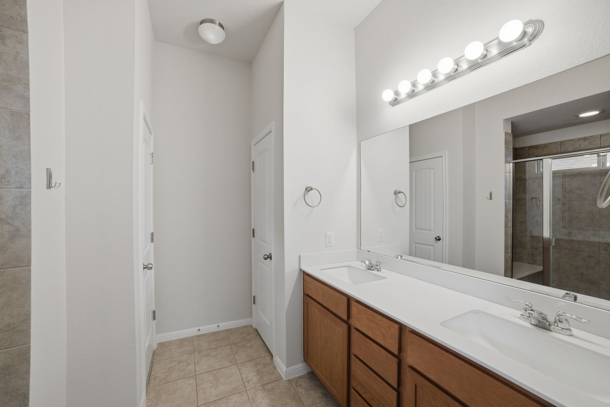 514 Nautical Loop Kyle, TX 78640 - Photo 14 of 24 Dual vanities and a spacious shower elevate daily routines in this well-appointed bathroom.