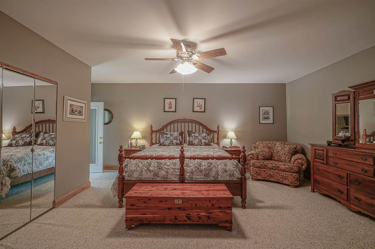1052 South Harmony Road Oregon, IL 61061 - Photo 15 of 25 a bedroom with furniture and a chandelier