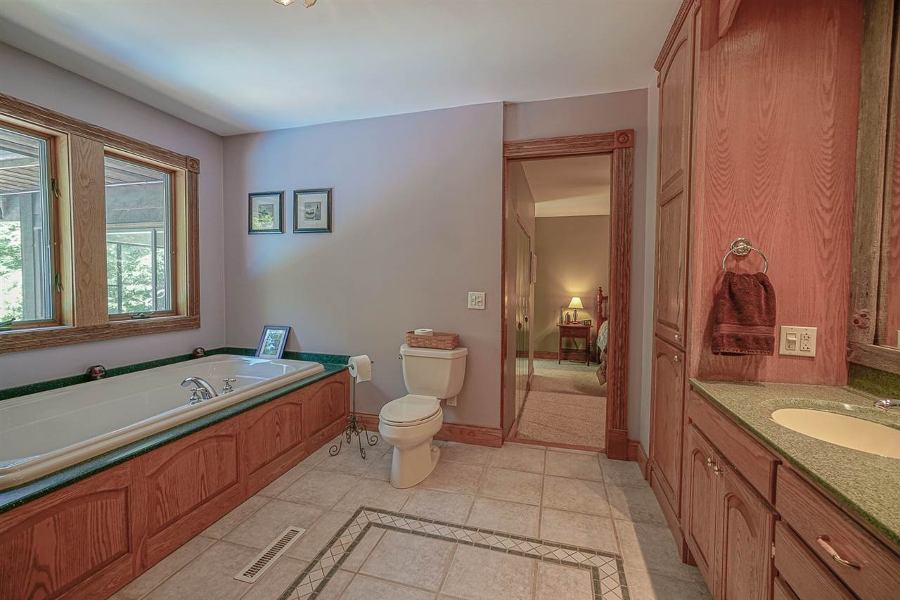 1052 South Harmony Road Oregon, IL 61061 - Photo 16 of 25 a spacious bathroom with a granite countertop sink and a large mirror