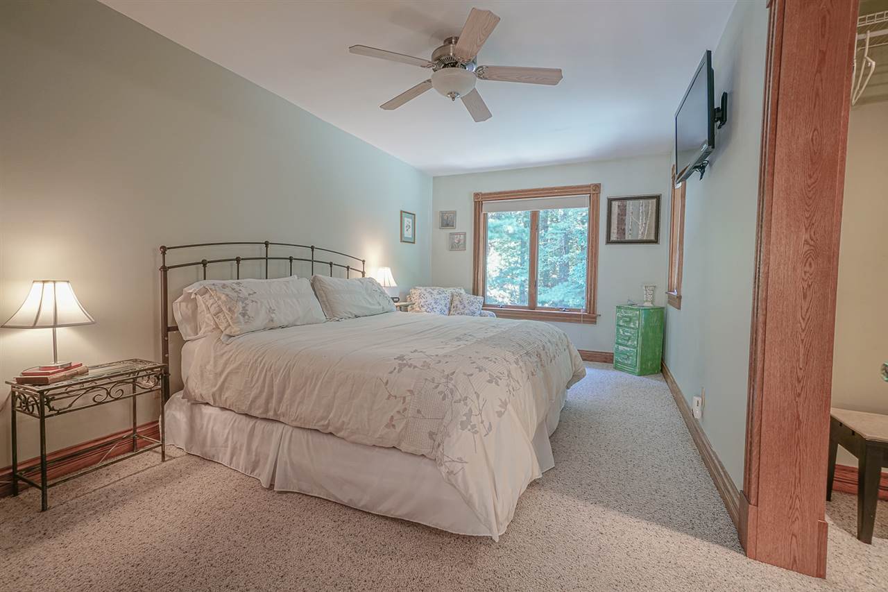 1052 South Harmony Road Oregon, IL 61061 - Photo 19 of 25 a spacious bedroom with a bed and a chandelier