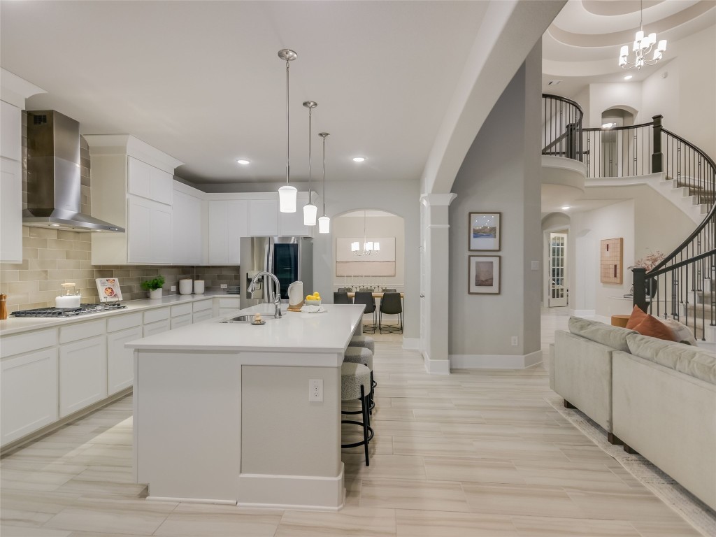 2610 Sunset Vista Circle, Unit 16 Spicewood, TX 78669 - Photo 12 of 28 Kitchen with a chandelier, arched walkways, pendant lighting, and recessed lighting