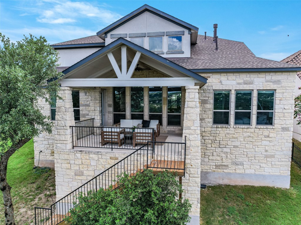 2610 Sunset Vista Circle, Unit 16 Spicewood, TX 78669 - Photo 22 of 28 View of front facade featuring stone siding, stairs, roof with shingles, and an outdoor living space