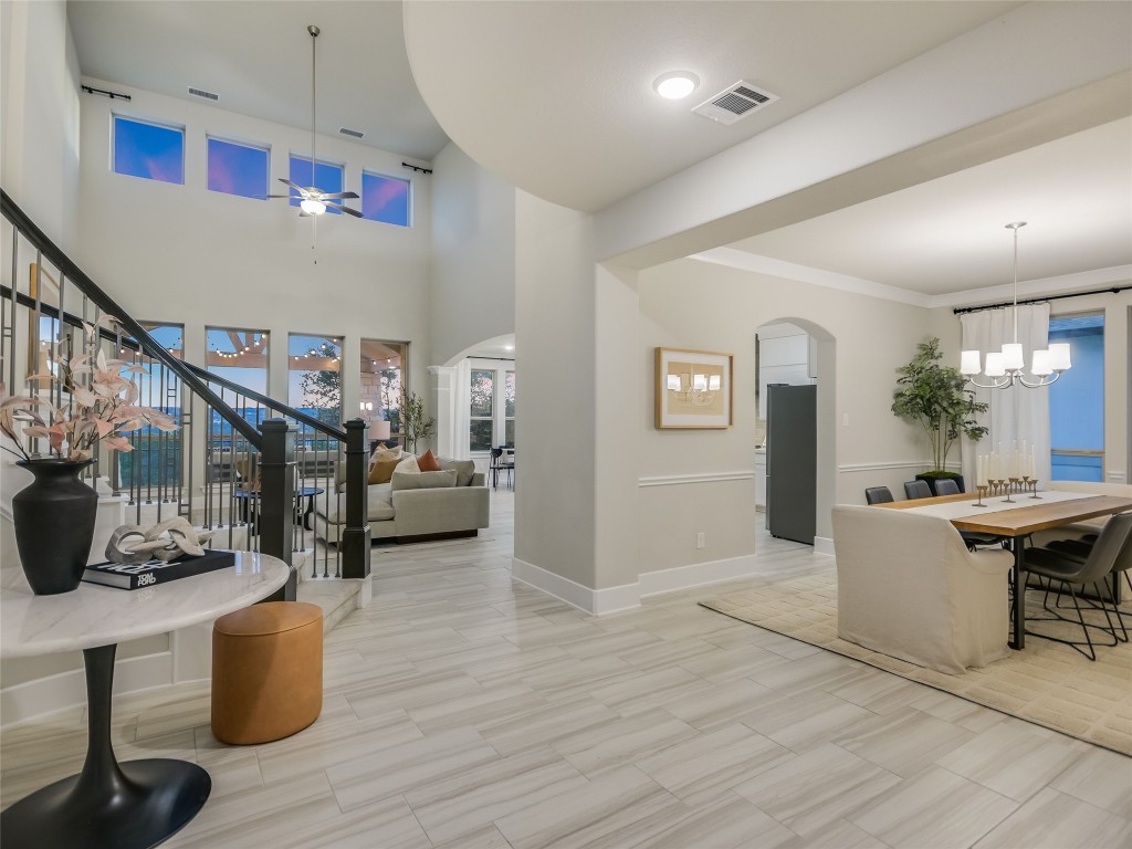 2610 Sunset Vista Circle, Unit 16 Spicewood, TX 78669 - Photo 7 of 28 Entrance foyer with arched walkways, stairs, a chandelier, and ceiling fan