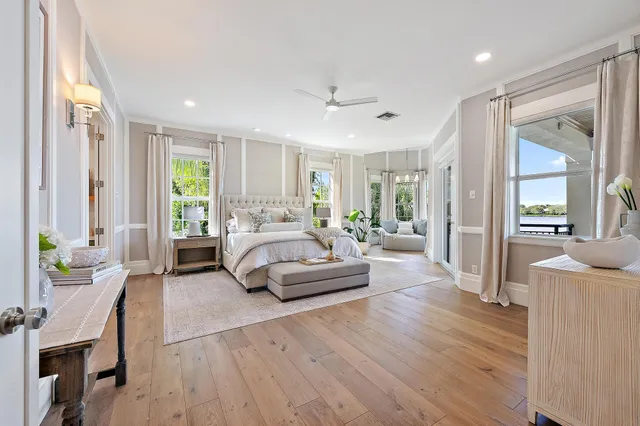 a spacious bedroom with a bed a dresser and next to a window