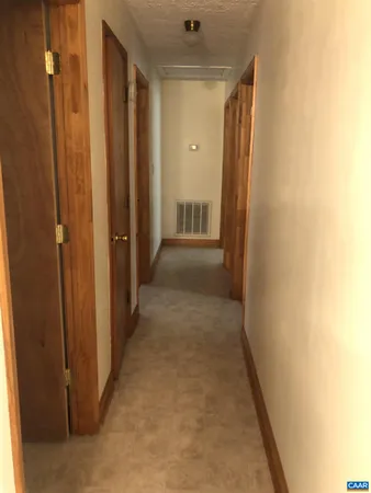 a view of a hallway with wooden shelves
