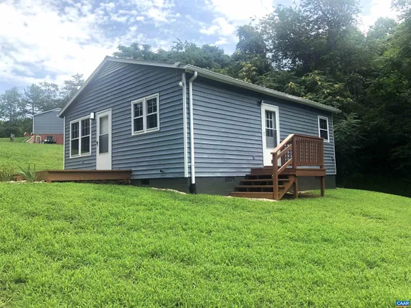 a backyard of a house with table and chairs
