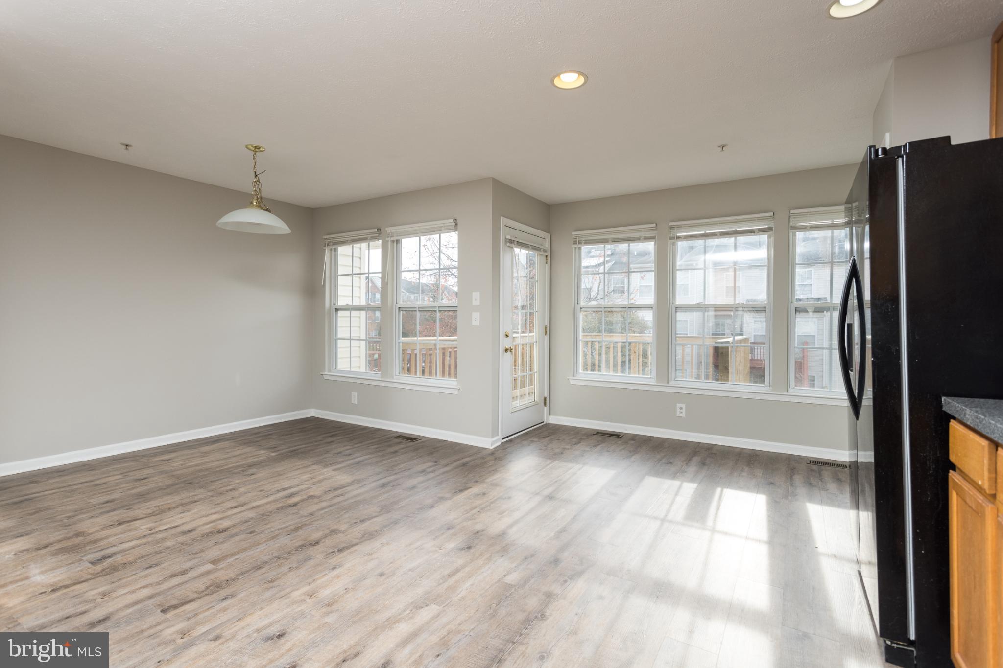 9899 Decatur Road Baltimore, MD 21220 - Photo 11 of 36 a view of an empty room with a window and wooden floor