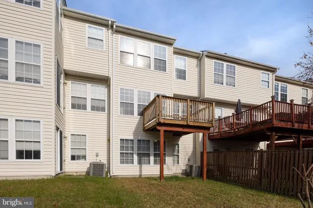 a view of a house with wooden deck and a fence
