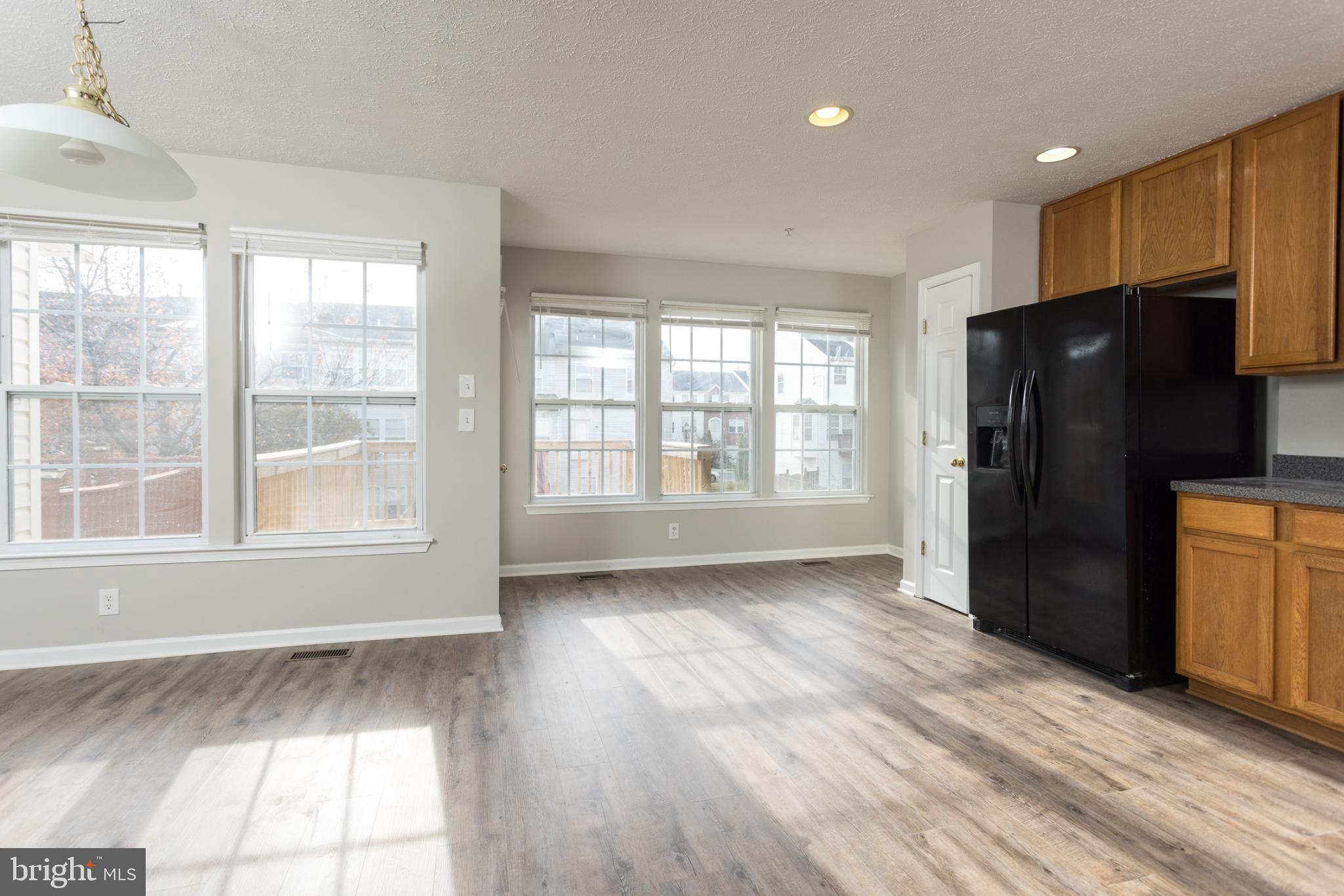 9899 Decatur Road Baltimore, MD 21220 - Photo 9 of 36 a view of an empty room with wooden floor and a window
