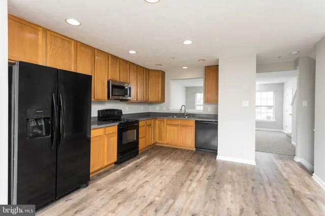 a kitchen with stainless steel appliances granite countertop a refrigerator and a stove top oven