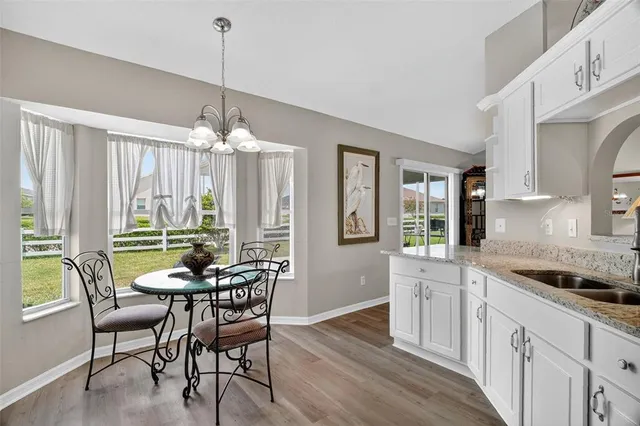 a dining room with furniture a chandelier and wooden floor