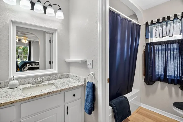 a en suite bathroom with a granite countertop sink and a mirror