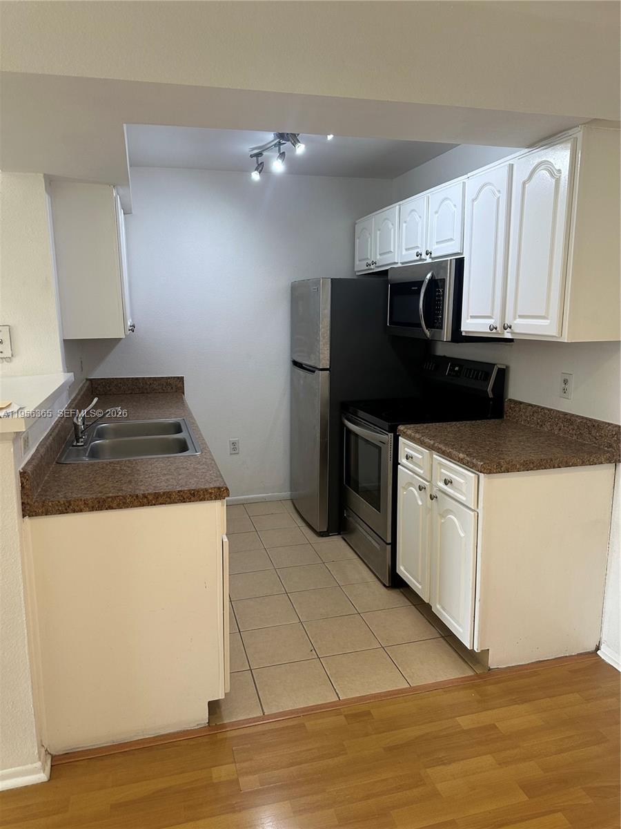 15560 Southwest 104th Terrace, Unit 625 Miami, FL 33196 - Photo 9 of 14 a kitchen with a sink a stove and refrigerator