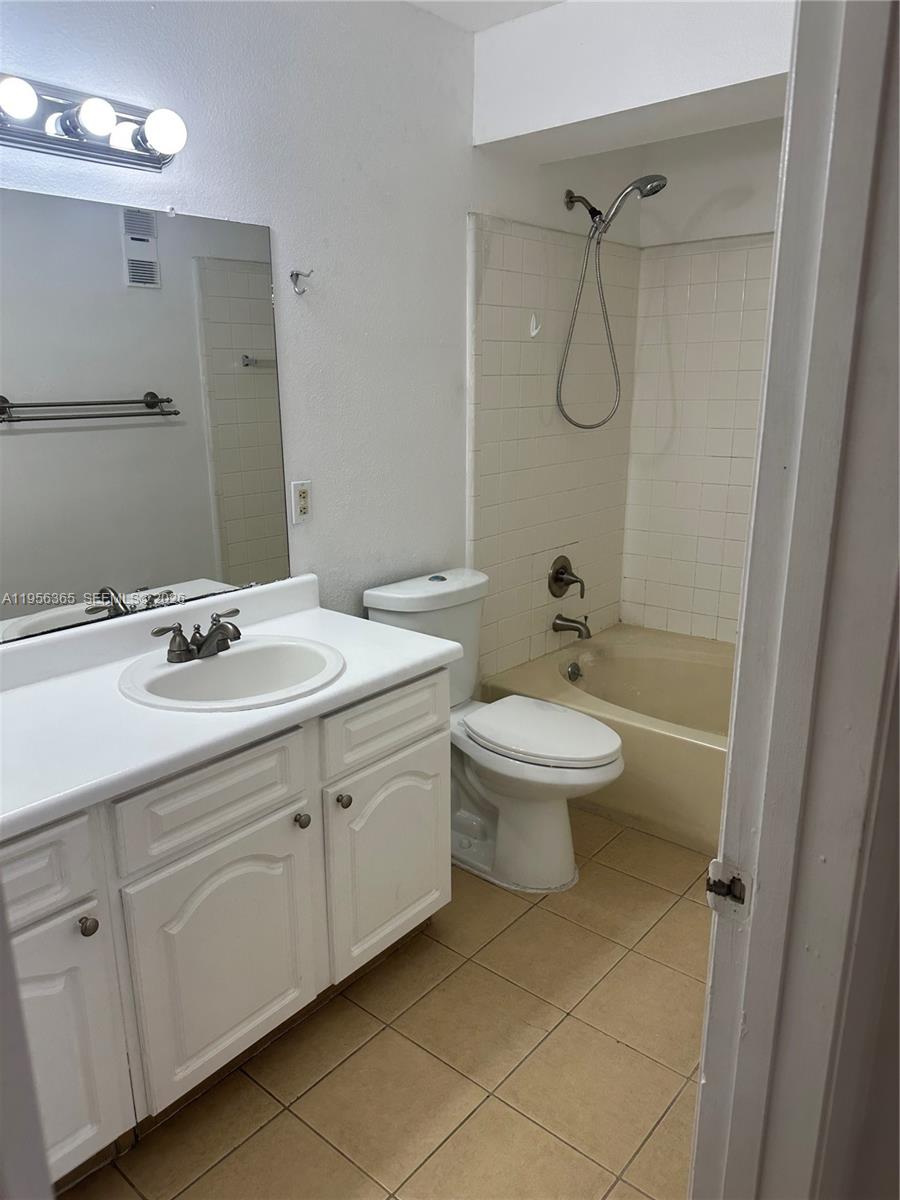 15560 Southwest 104th Terrace, Unit 625 Miami, FL 33196 - Photo 10 of 14 a bathroom with a granite countertop sink a toilet and a mirror