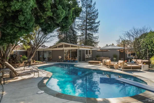a view of a house with backyard patio and sitting area