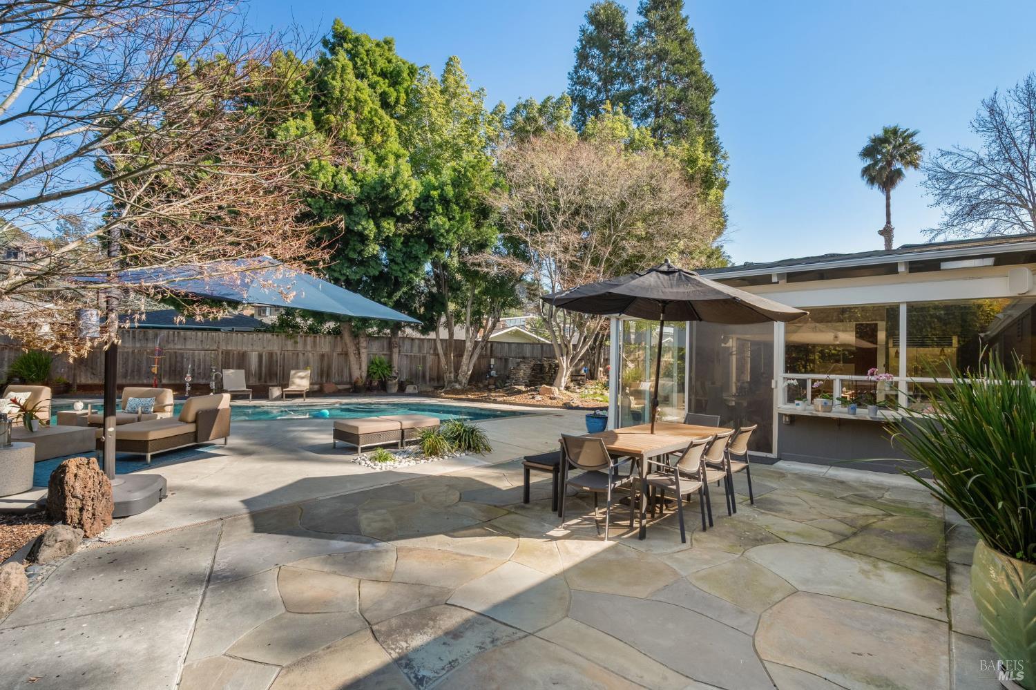 43 La Crescenta Way San Rafael, CA 94901 - Photo 25 of 28 a view of a patio with table and chairs potted plants and a large tree