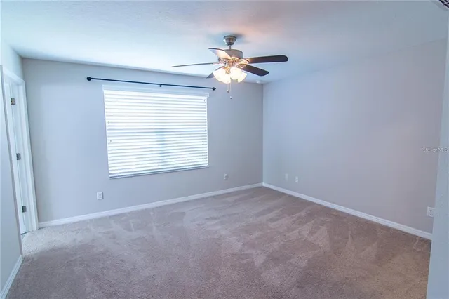 a view of a room with a ceiling fan and a window