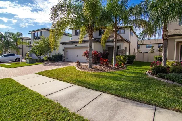 a view of a house with a yard and palm trees