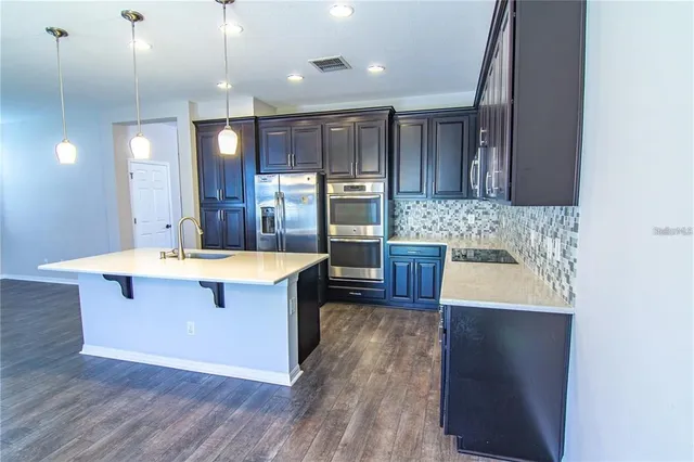 a large kitchen with kitchen island a sink stainless steel appliances and cabinets