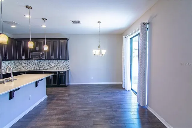 a view of kitchen with a sink and a refrigerator