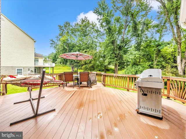 a view of a roof deck with table and chairs under an umbrella with wooden floor
