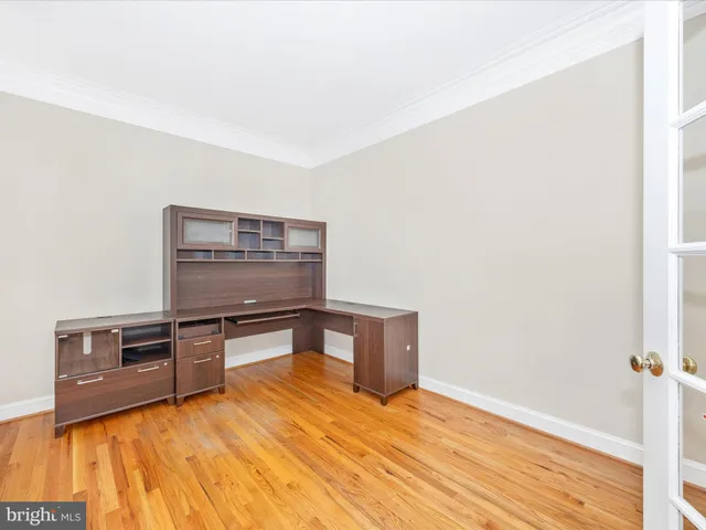 a view of kitchen and empty room with wooden floor