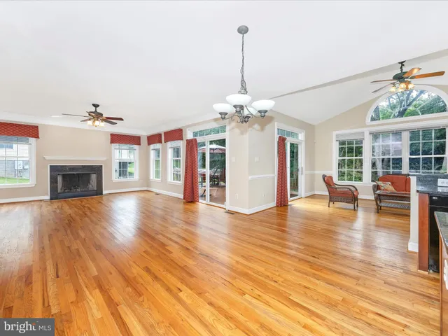 a view of a livingroom with wooden floor and a fireplace