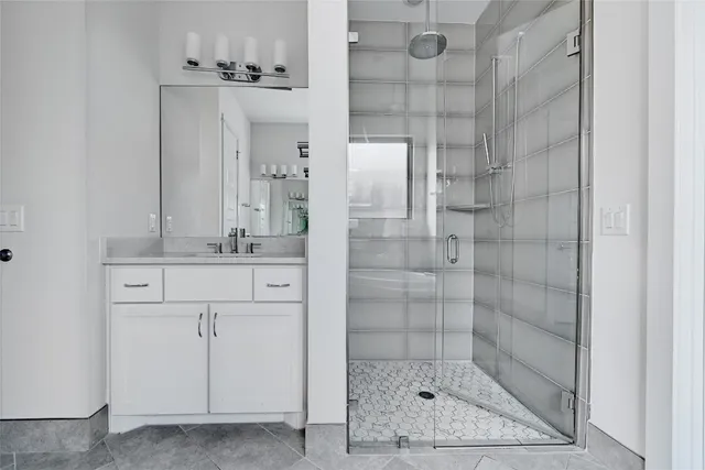 a bathroom with a shower sink and mirror