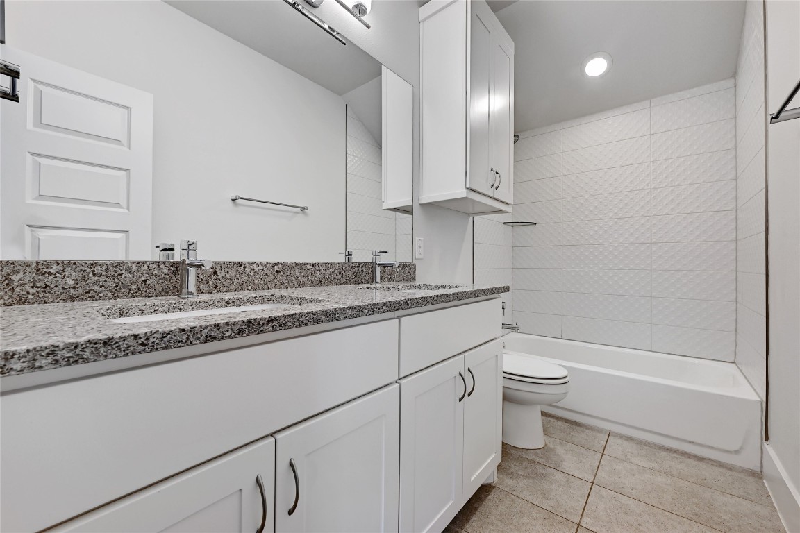 1815 West 38th Street Austin, TX 78731 - Photo 21 of 25 a bathroom with a granite countertop sink a toilet and bathtub