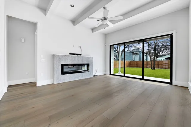 a view of an empty room with a fireplace and a window