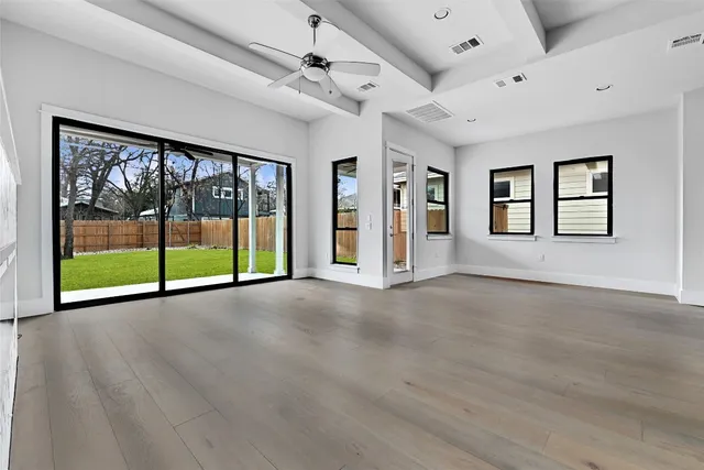 a view of an empty room with a window and a fireplace
