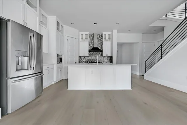 a large white kitchen with stainless steel appliances