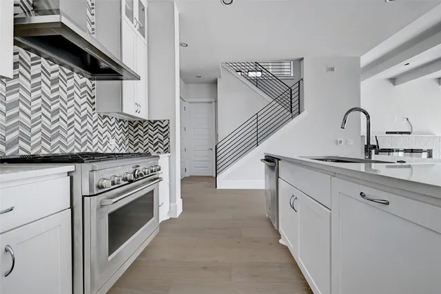 a kitchen with white cabinets and appliances