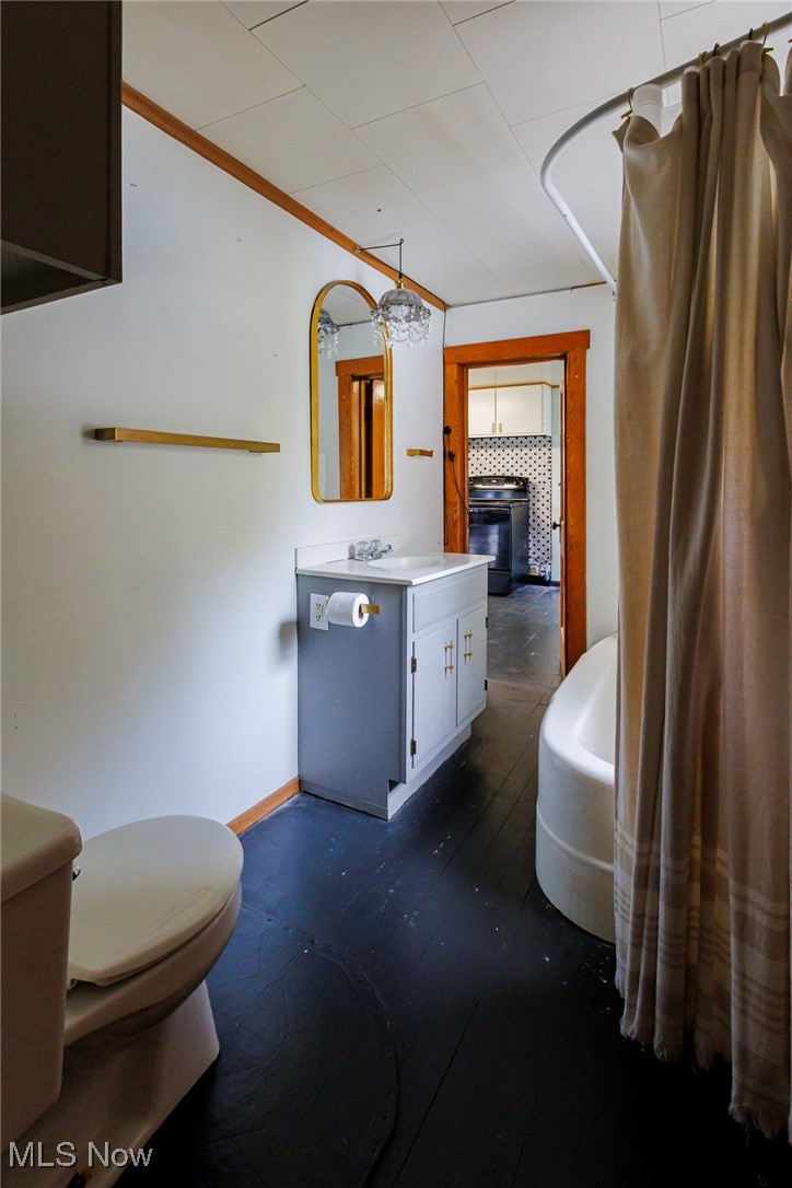 7997 Chestnut Ridge Road Northwest Beach City, OH 44608 - Photo 12 of 31 Bathroom featuring toilet, vanity, baseboards, and wood finished floors