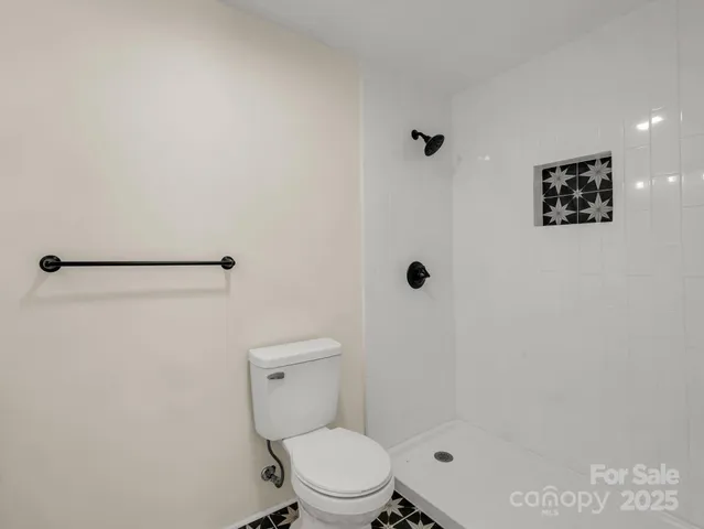 a white toilet sitting next to a shower