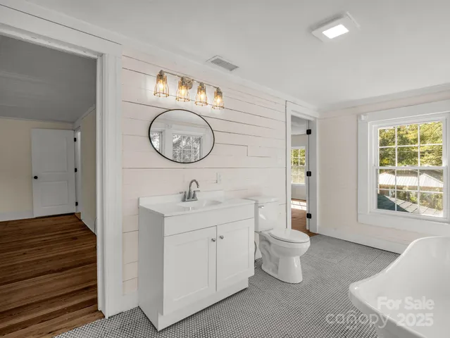 a bathroom with a toilet a sink and a large mirror