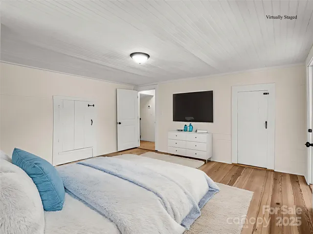 a bedroom with a bed tv and a window