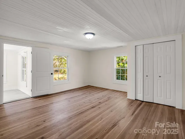 an empty room with window and wooden floor