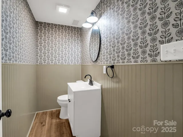 a bathroom with a sink a toilet and mirror