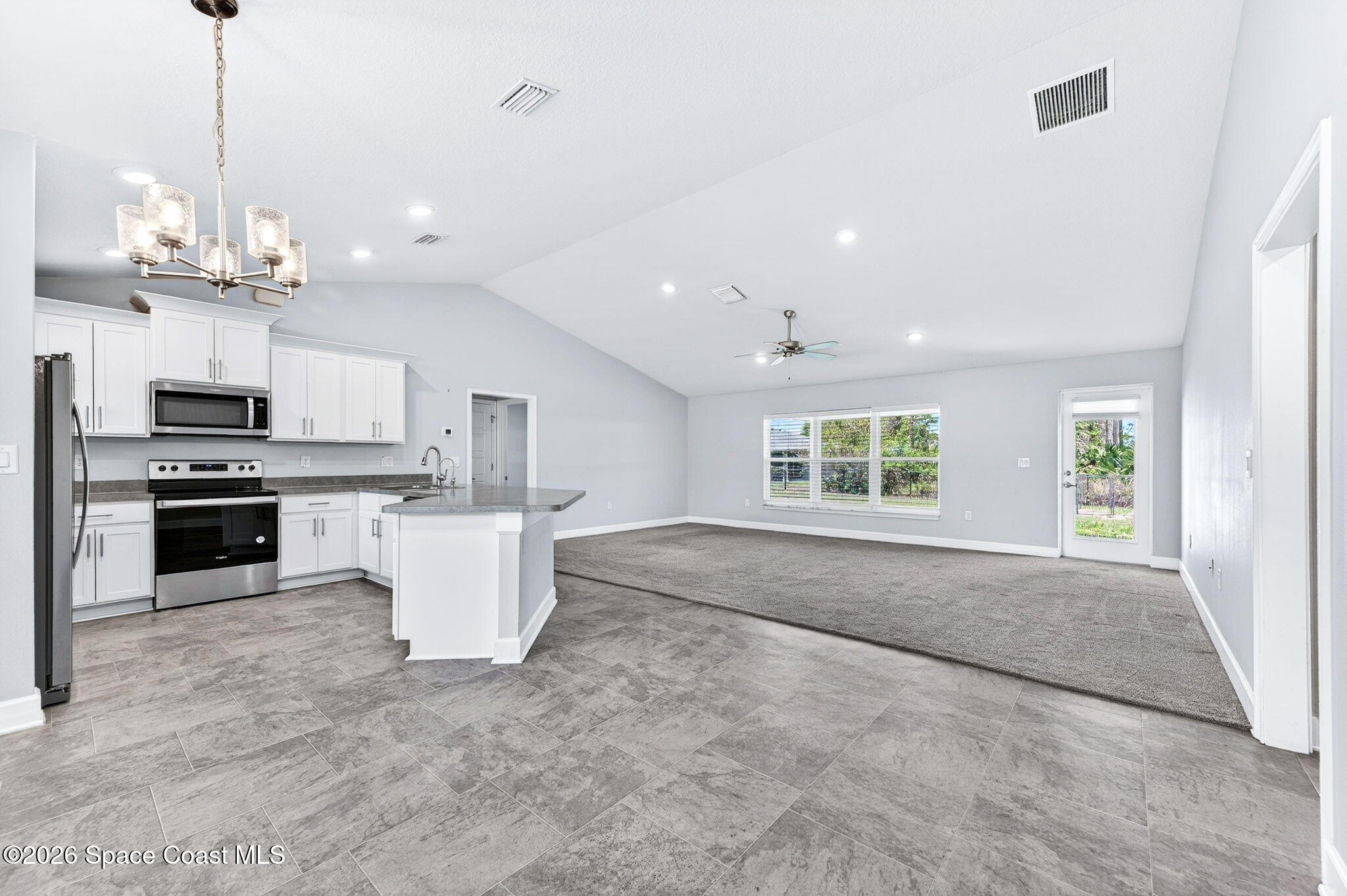 717 Gelaso Street Southwest Palm Bay, FL 32908 - Photo 48 of 48 a large kitchen with kitchen island a stove a sink a center island and windows