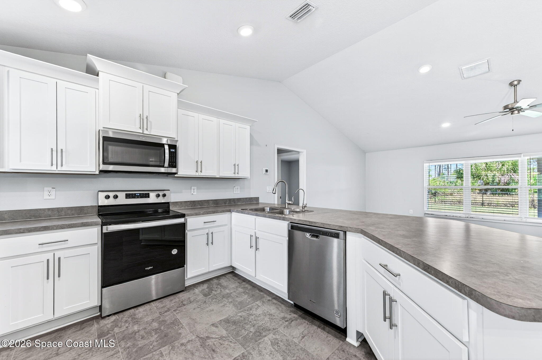 717 Gelaso Street Southwest Palm Bay, FL 32908 - Photo 13 of 48 a kitchen with stainless steel appliances granite countertop white cabinets a sink and a stove